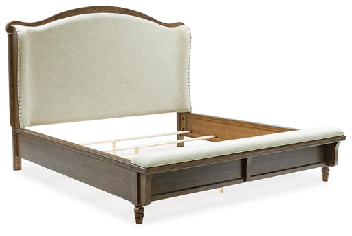 Ashley Furniture Sturlayne upholstered bed with a padded headboard and neutral fabric, shown from an angled side view.