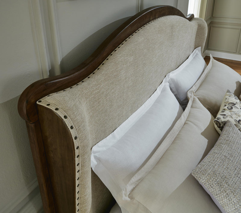 Close-up of Ashley Furniture's Sturlayne upholstered bed showing detailed fabric and tufted headboard design.