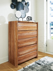 Ashley Furniture Dressonni chest of drawers with a sleek wooden finish and multiple drawers for bedroom storage.