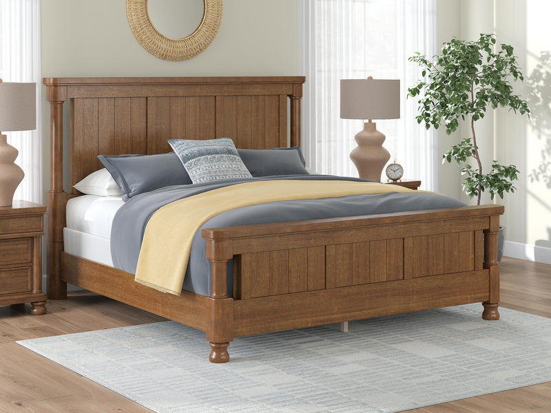 Ashley Furniture Rowlenstown bedroom set with a bed, dresser, and nightstands in a modern design, shown in a cozy bedroom setting.
