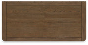 Ashley Furniture Cabalynn chest of drawers with a sleek wooden top and multiple storage drawers.