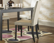 Ashley Furniture Kimonte dining chair with dark wood finish and upholstered seat, shown from a side angle.
