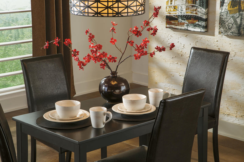Ashley Furniture Kimonte dining chair with dark wood legs and beige upholstered seat and back, shown from a side angle.