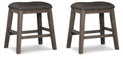 Set of Ashley Furniture Caitbrook counter height barstools with dark wood finish and upholstered seats, arranged around a dining table.