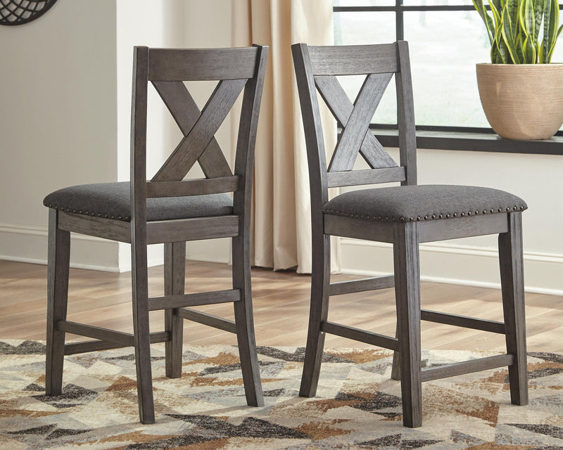 Set of Ashley Furniture Caitbrook Counter Height Barstools, featuring wooden seats and sturdy metal frames for a modern dining look.