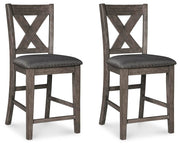 Set of Ashley Furniture Caitbrook counter height barstools with wooden seats and metal frames, arranged around a dining table.