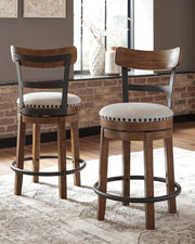 Ashley Furniture Valebeck counter height bar stool with wooden frame and cushioned seat, shown in a natural wood finish.