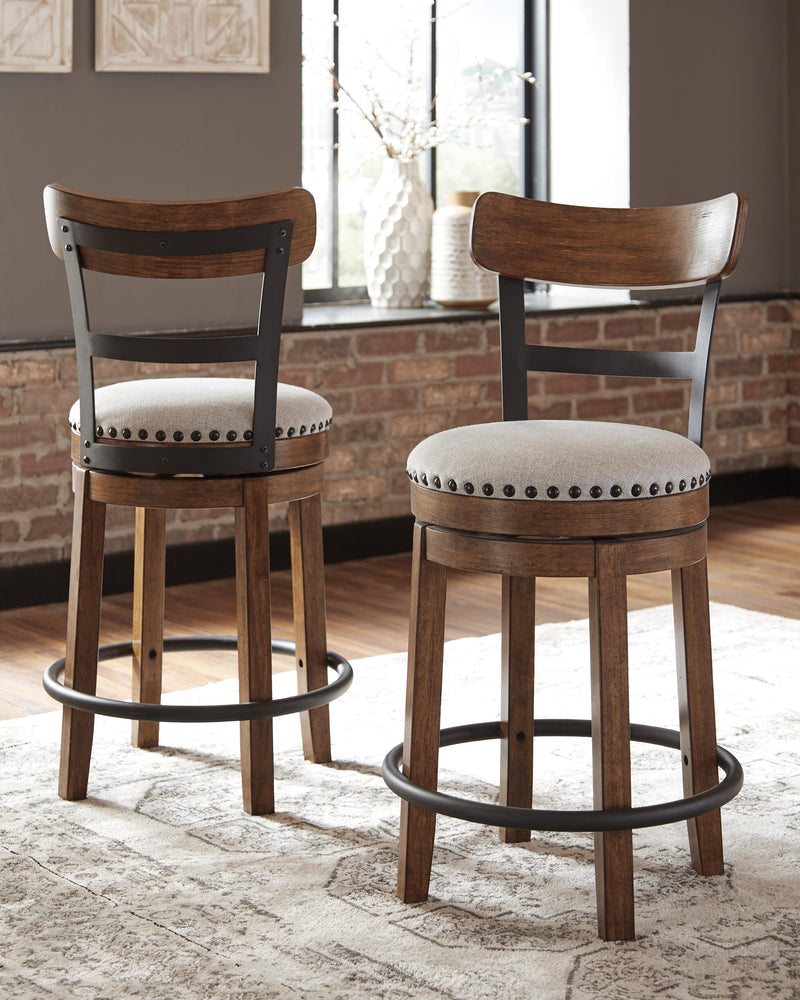 Ashley Furniture Valebeck counter height bar stool with wooden frame and cushioned seat, shown in a natural wood finish.