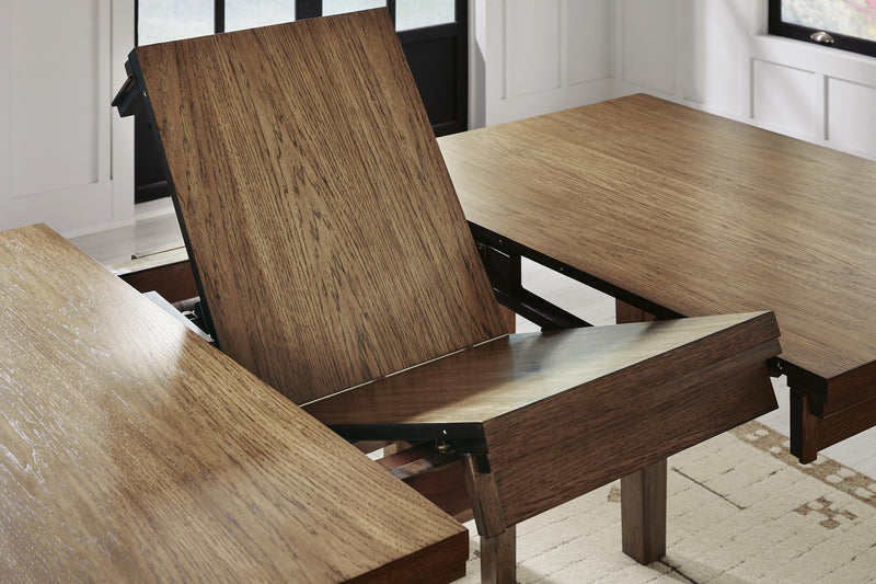 Ashley Furniture Urbinforte dining room set with a leaf-design table and matching chairs, shown in a modern dining space.
