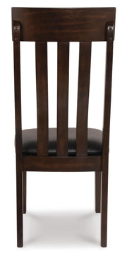 Ashley Furniture Haddigan dining chair with dark wooden legs and upholstered seat, shown from the back.