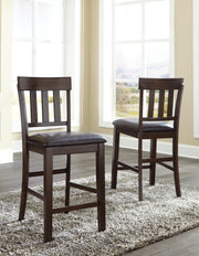 Ashley Furniture Haddigan bar stool set featuring four stylish wooden stools with upholstered seats and metal footrests.