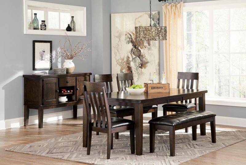 Ashley Furniture Haddigan dining bench with wood finish and upholstered seat, shown in a modern dining room setting.