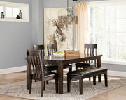 Ashley Furniture Haddigan dining extension table with a wooden finish, shown extended with matching chairs.