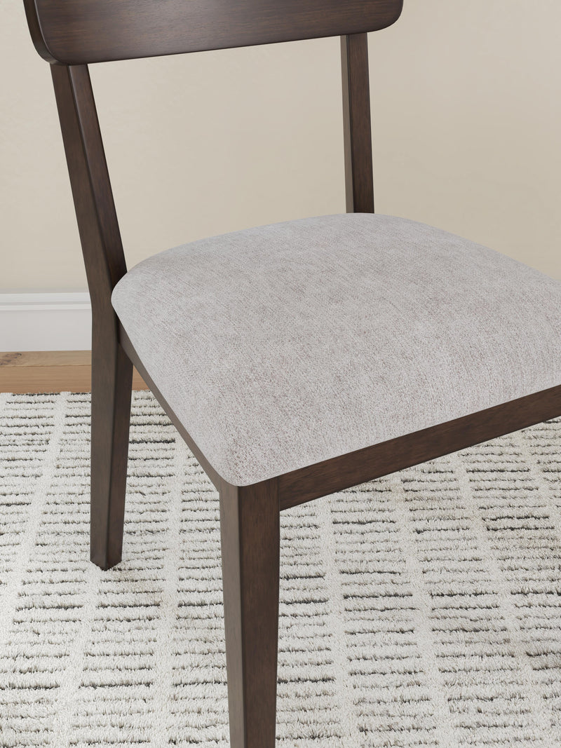 Close-up of Ashley Furniture Mallenette dining chair with dark wood finish and upholstered seat, showcasing detailed craftsmanship.