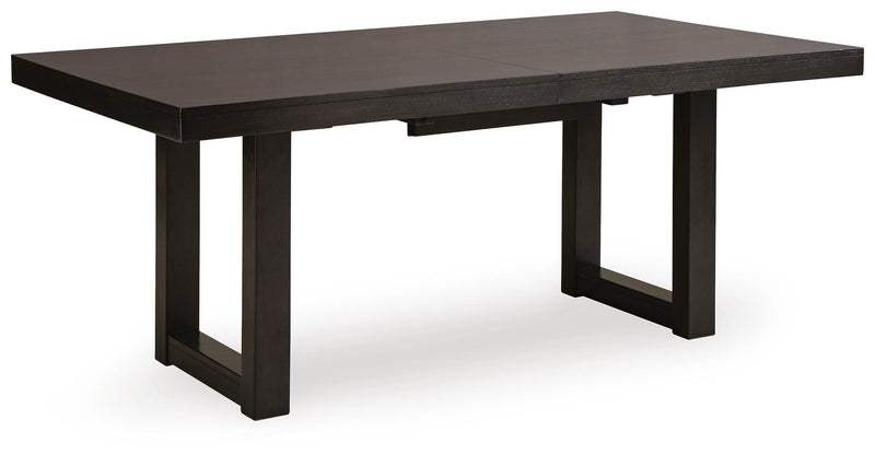 Ashley Furniture Neymorton dining room set with a large wood table, six matching chairs, and a leaf extension, shown from an angled view.