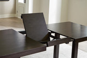 Ashley Furniture Neymorton dining room set with a leaf-patterned table and matching chairs, showcasing elegant wood finish and detailed design.