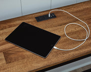 Ashley Furniture Wildenauer counter height dining table with built-in USB ports and three matching barstools, showcasing modern wood design.