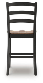 Ashley Furniture Wildenauer counter height barstool with a wooden frame and cushioned seat, shown from the back in a modern dining setting.