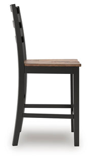 Ashley Furniture Wildenauer counter height barstool with wooden legs and a cushioned seat, shown from a side angle.