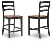 Ashley Furniture Wildenauer counter height barstool with wooden legs and a cushioned seat, shown from an alternate angle.