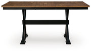 Wildenauer counter height butterfly extension table by Ashley Furniture, showing the table's wood surface with extended leaf in view.