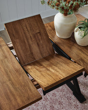 Close-up of Ashley Furniture Wildenauer counter height butterfly extension table showing the leaf and detailed wood finish.