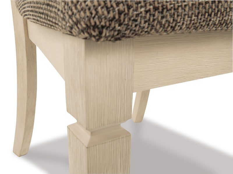 Close-up of Ashley Furniture Bolanburg dining chair showing dark wood legs and upholstered beige seat with detailed stitching.