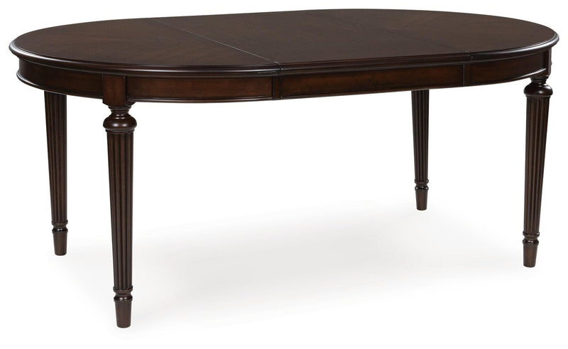 Ashley Furniture Lavinton dining room set with a table, leaf extension, and matching chairs, shown from an angled perspective.