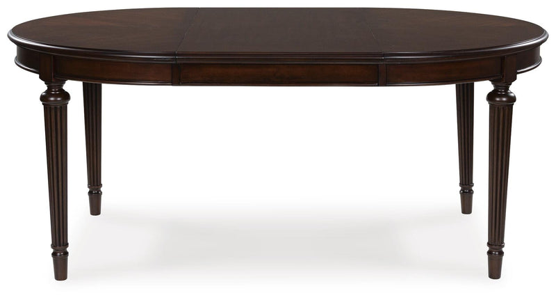 Ashley Furniture Lavinton dining extension table with leaf, wood finish, and sleek design, shown from head-on view.