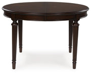 Ashley Furniture Lavinton dining extension table with a wood finish, showing the table with the leaf extended and a sleek, modern design.