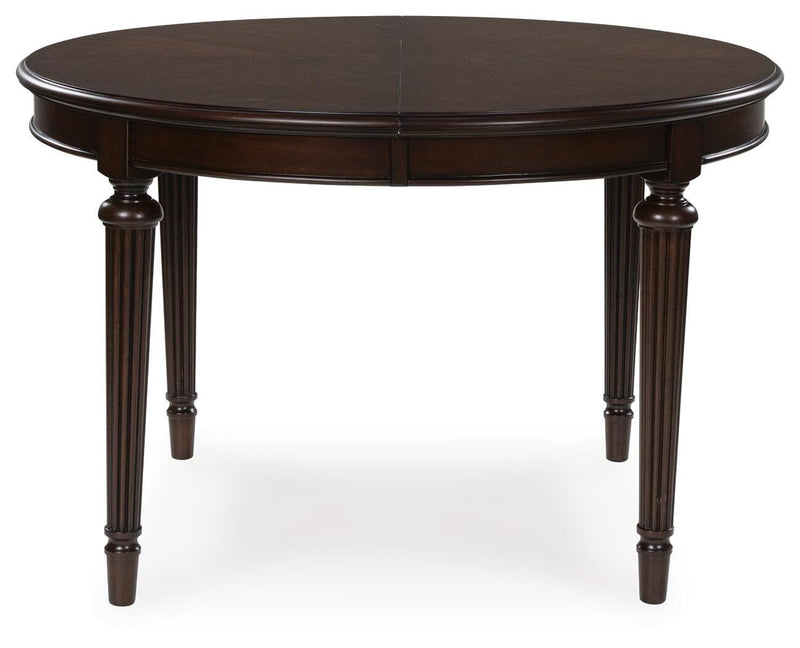 Ashley Furniture Lavinton dining extension table with a wood finish, showing the table with the leaf extended and a sleek, modern design.