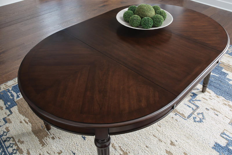 Ashley Furniture Lavinton dining extension table with a leaf detail, showcasing its elegant wooden surface and extendable design.