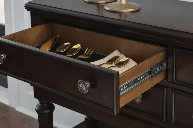 Ashley Furniture Lavinton dining server with wood finish, featuring drawers and shelves for stylish storage and serving needs.