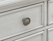 Ashley Furniture Montelaine dining server with detailed knob hardware and elegant wood finish, showcasing its storage and design features.