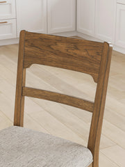 Close-up of a Cabalynn counter height barstool by Ashley Furniture, showing the detailed wood finish and upholstered seat.