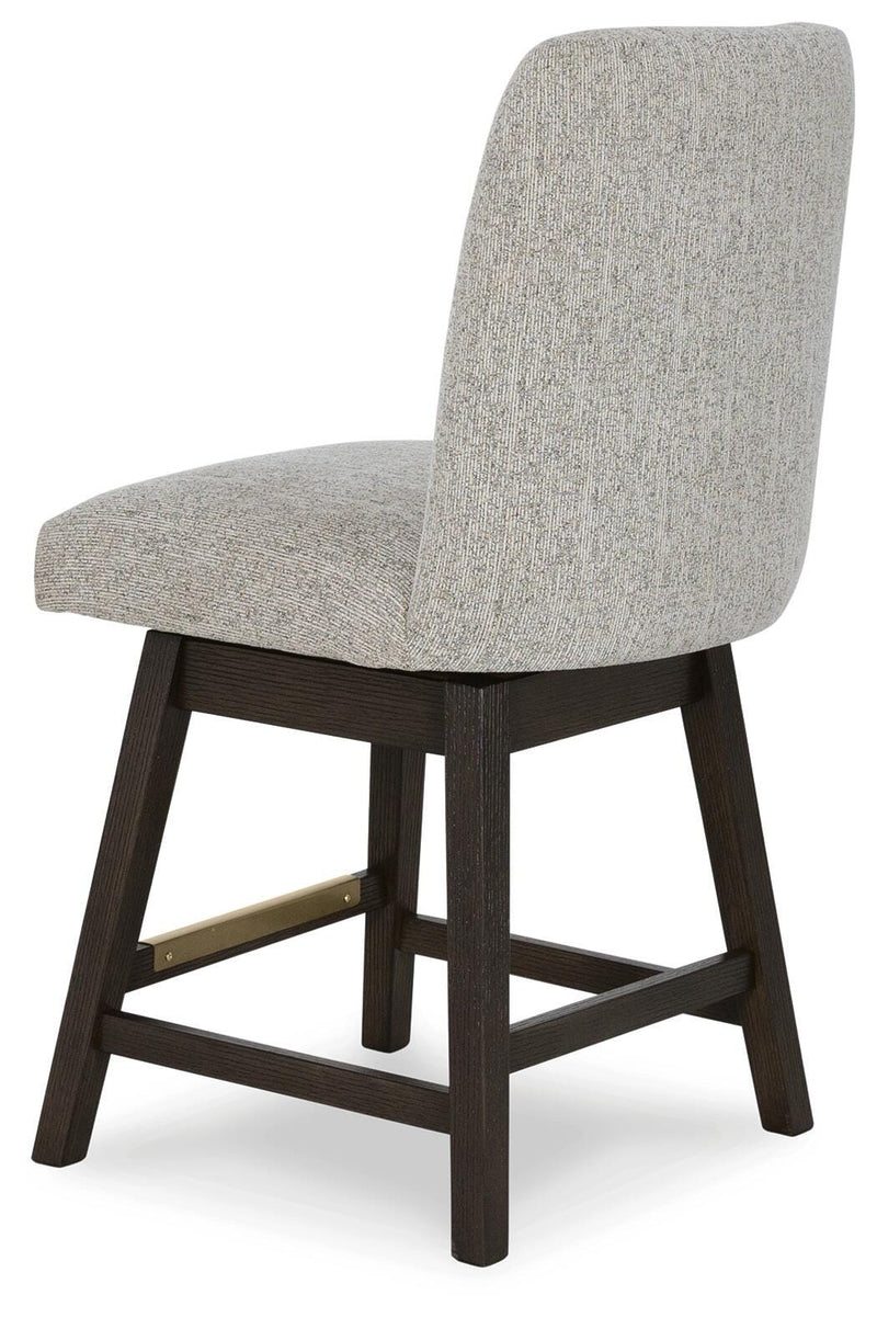 Ashley Furniture dining room set with a wooden table and six upholstered chairs, shown from an angled back view.