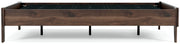 Ashley Furniture Calverson Bed with neutral-toned upholstered headboard and wooden frame, shown in a side view.