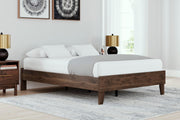 Ashley Furniture Calverson Bed with a sturdy wooden frame and upholstered headboard, shown in a cozy bedroom setting.