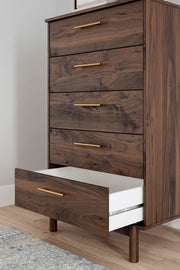 Close-up of the Ashley Furniture Calverson Chest of Drawers showing its detailed wood finish and sleek drawer handles.