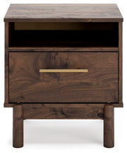 Ashley Furniture Calverson Nightstand with a sleek wood finish and modern design, featuring a single drawer and open shelf.