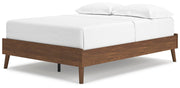 Ashley Furniture Fordmont Bed with upholstered headboard and wooden frame, shown from an angled perspective.