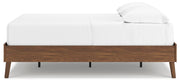 Ashley Furniture Fordmont Bed with a dark wood finish and elegant panel design, shown from a side angle.