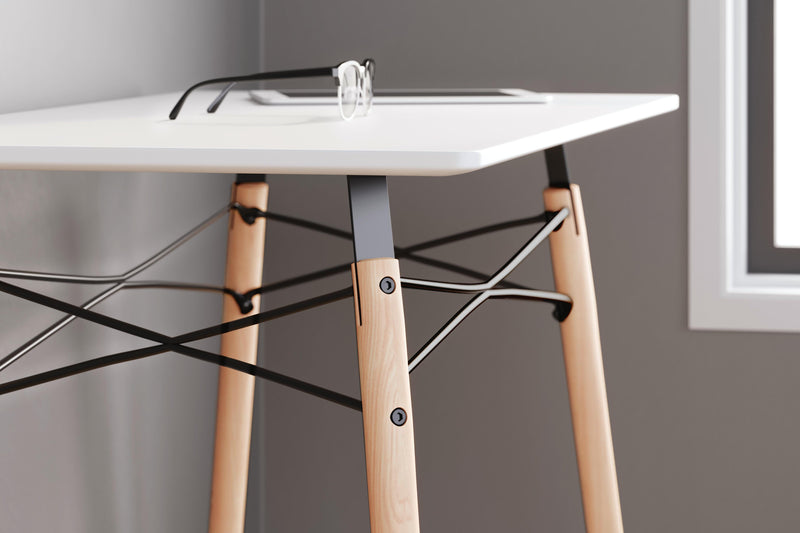 Ashley Furniture Jaspeni home office desk with a sleek wooden surface and modern design, ideal for workspace organization.