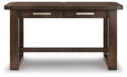 Ashley Furniture Breckington home office set with a wooden desk, matching chair, and shelving unit in a modern office space.