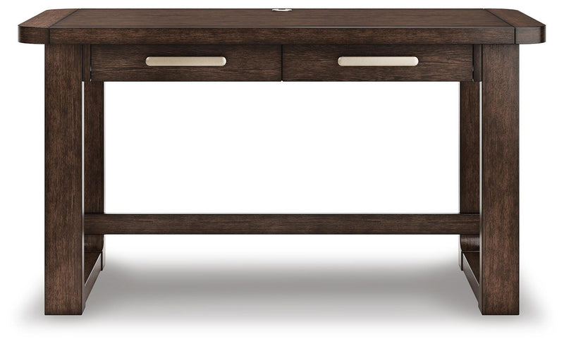 Ashley Furniture Breckington home office set with a wooden desk, matching chair, and shelving unit in a modern office space.