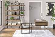 Ashley Furniture Montia home office set includes a desk and storage unit with a modern design, shown in a well-lit room setting.