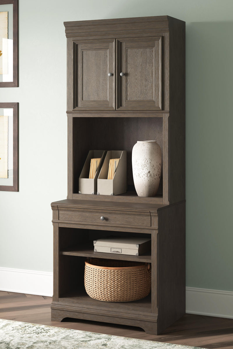 Ashley Furniture Janismore bookcase with multiple shelves and a dark wood finish, ideal for home storage and display.