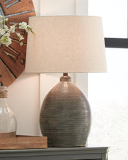 Joyelle table lamp by Ashley Furniture featuring a sleek design with a fabric shade and modern base, perfect for living room decor.