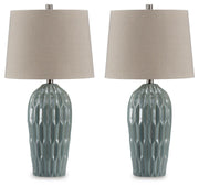 Pair of Hadbury table lamps by Ashley Furniture with cream fabric shades and dark bronze bases on a wooden surface.