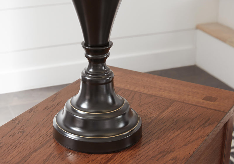 Pair of Darlita table lamps by Ashley Furniture with beige fabric shades and dark bronze bases, displayed on a wooden surface.